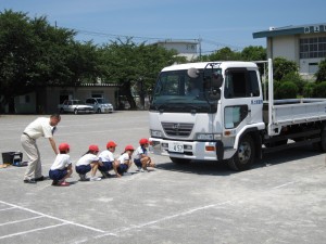 トラックの前にしゃがんでいる子たちは、運転席から見えません