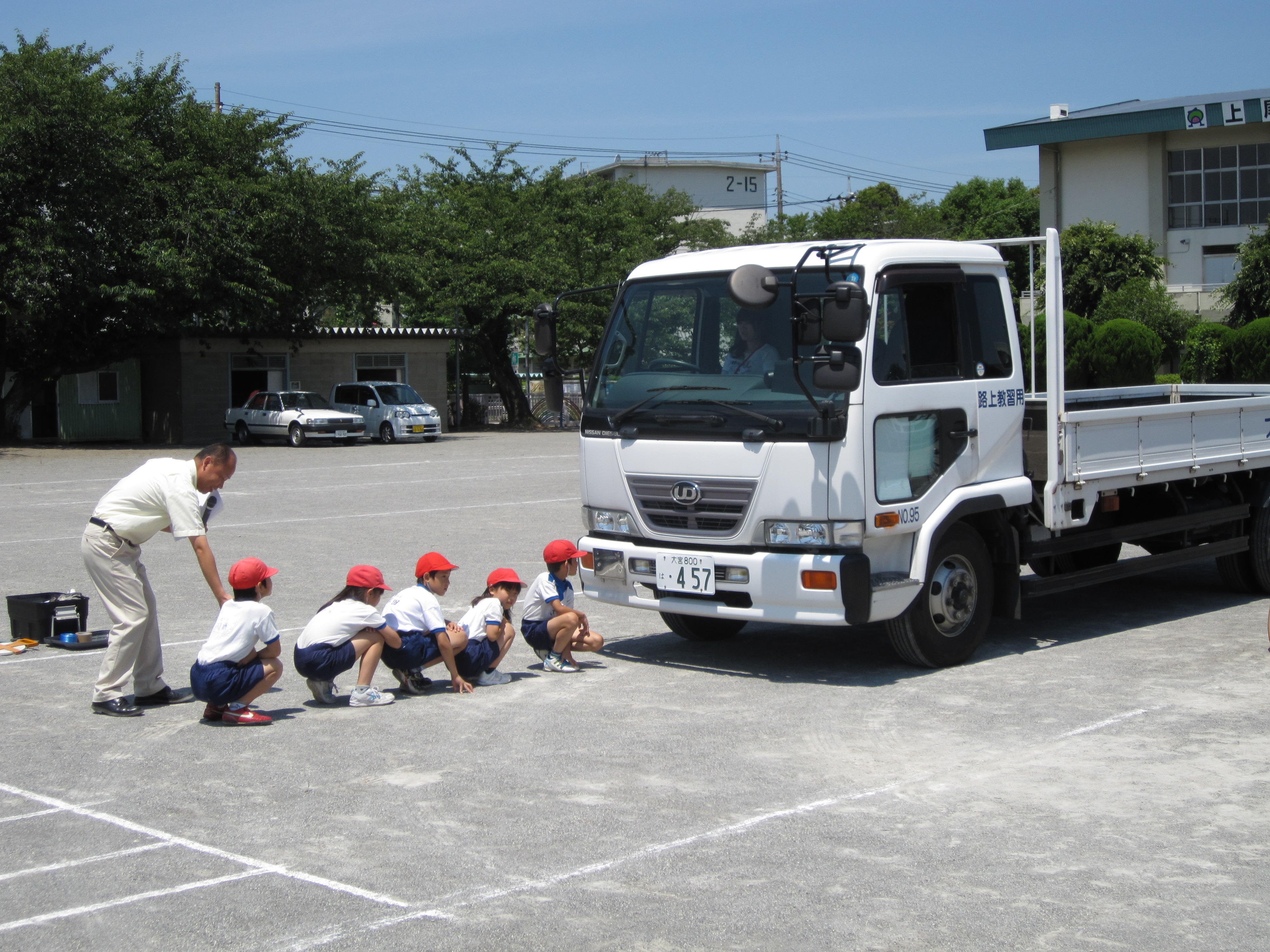 トラックの前にしゃがんでいる子たちは、運転席から見えません
